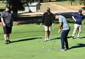 4 people playing golf
