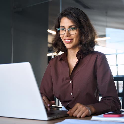 woman sitting at desk working on laptop